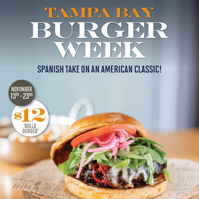 Close-up of Bulla Gastrobar’s signature ‘Bulla Burger’ topped with melted cheese, arugula, and pickled onions for Tampa Bay Burger Week 2025, benefiting Feeding Tampa Bay.