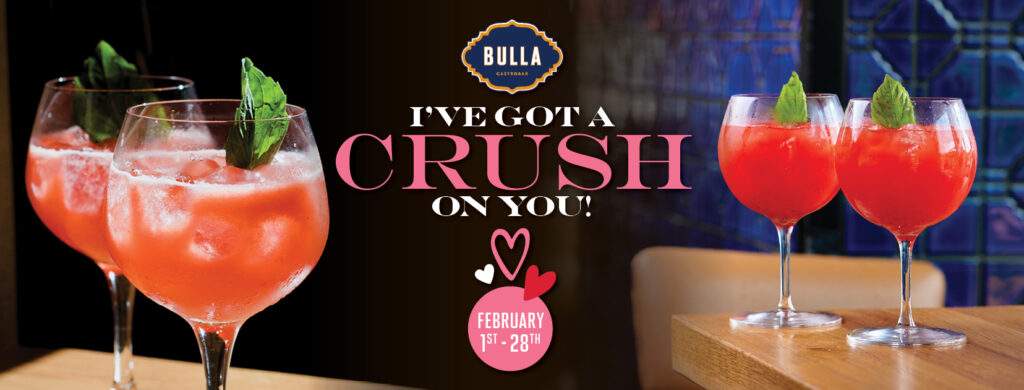 Two vibrant Strawberry Crush cocktails garnished with fresh mint sit on a bar table at Bulla Gastrobar, with text reading “I’ve Got a Crush on You,” highlighting the Valentine’s Day special available February 1–28.