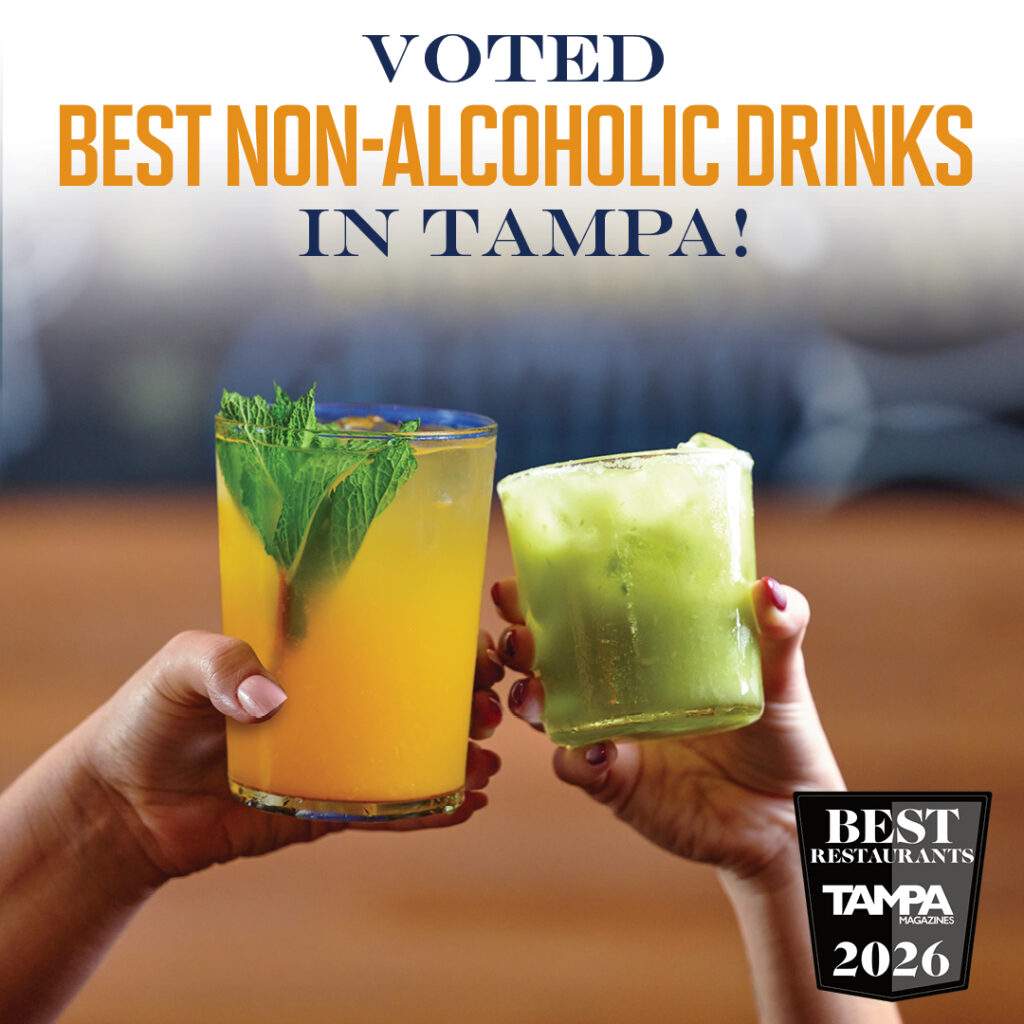 Two hands toasting colorful non-alcoholic drinks at Bulla Tampa, celebrating being voted Best Non-Alcoholic Drinks in Tampa by Tampa Magazine 2026.