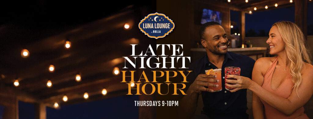 Couple toasting cocktails at Luna Lounge by Bulla during late night happy hour with warm evening ambiance