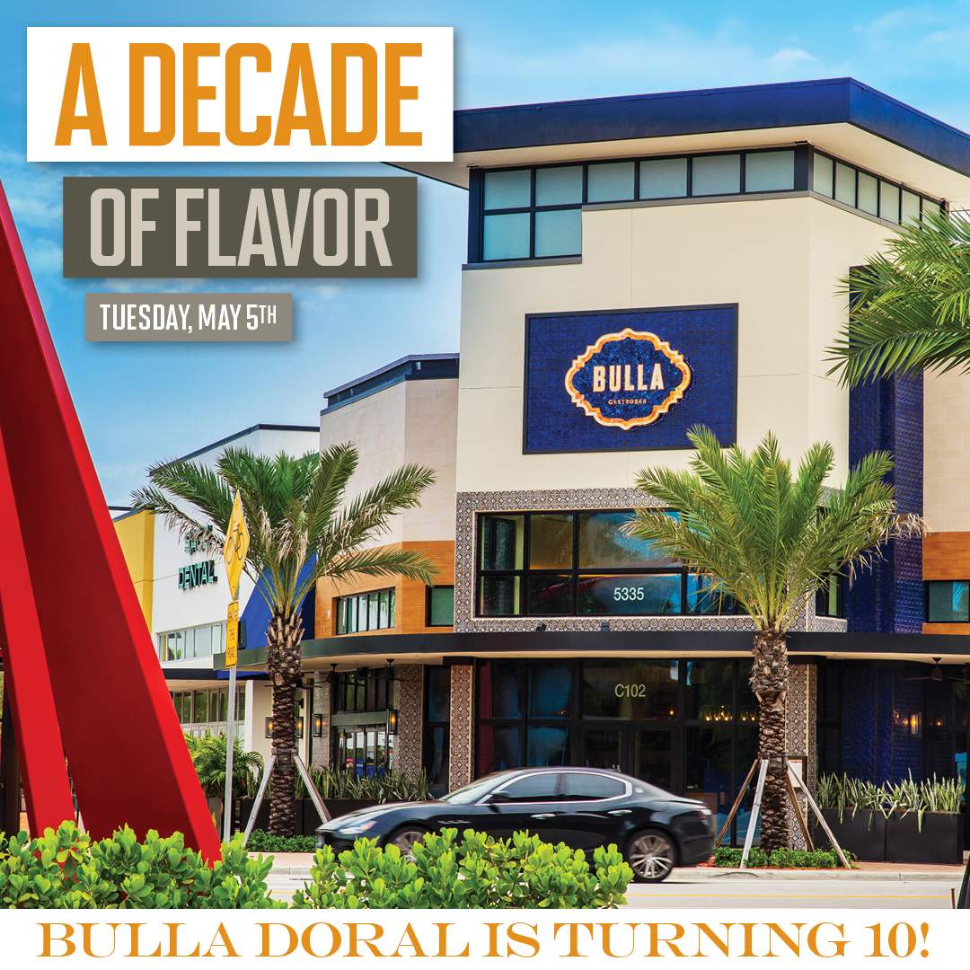 Exterior of Bulla Gastrobar Doral with palm trees and a car passing by. The image features bold text reading “A Decade of Flavor” and “Tuesday, May 5th,” along with messaging that Bulla Doral is celebrating its 10-year anniversary.
