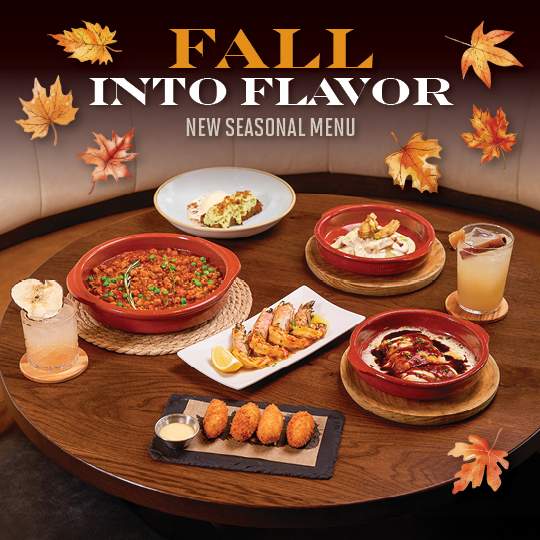Bulla Gastrobar Fall Menu featuring seasonal dishes and cocktails on a table with autumn leaves, showcasing the “Fall Into Flavor” new seasonal menu.